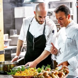 a couple of people cooking a commercial kitchen