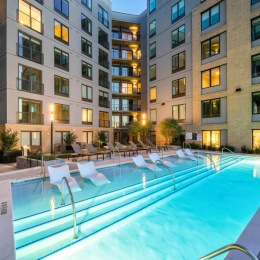swimming pool with lounge chairs in a courtyard