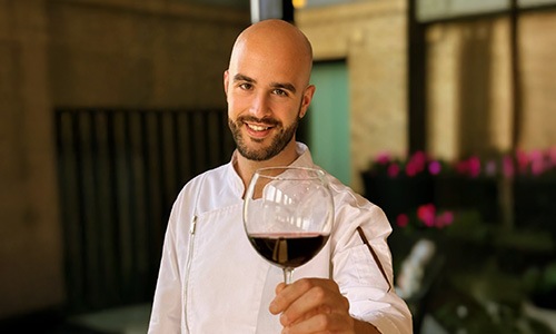 a person posing for a picture holding a glass of wine