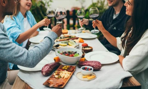 a group of people having a meal around an outdoor table