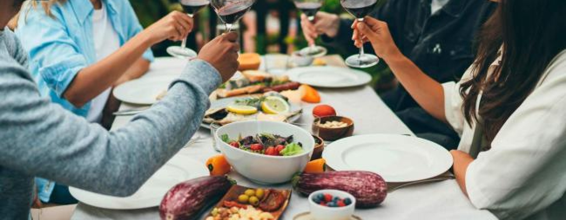 a group of people having a meal around an outdoor table