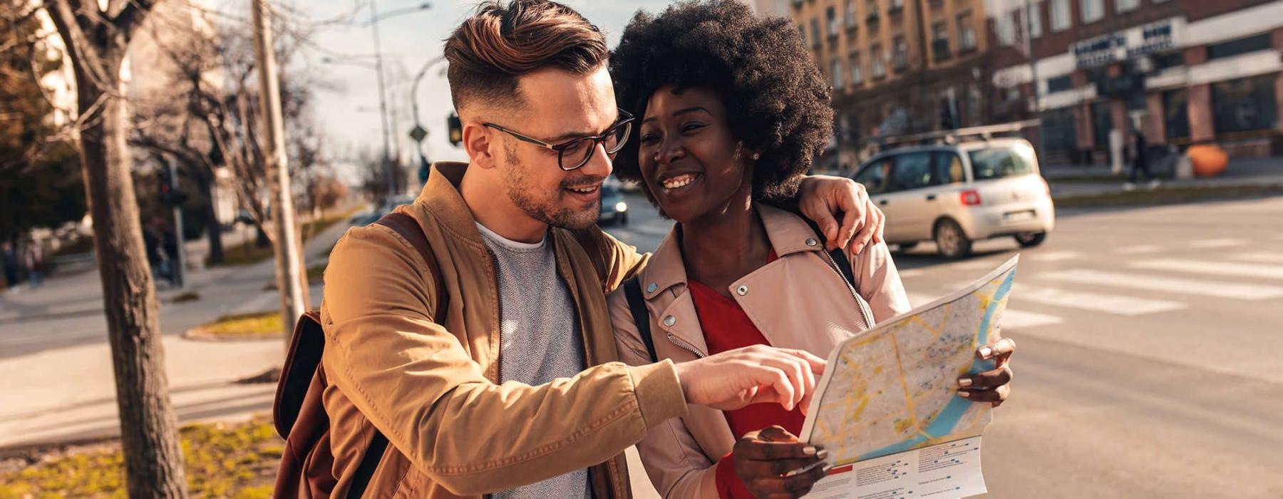 a man and woman looking at a map in the city