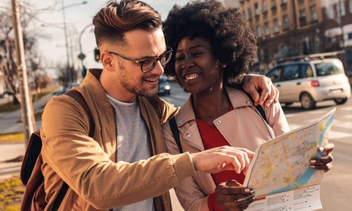 a man and woman looking at a map in the city